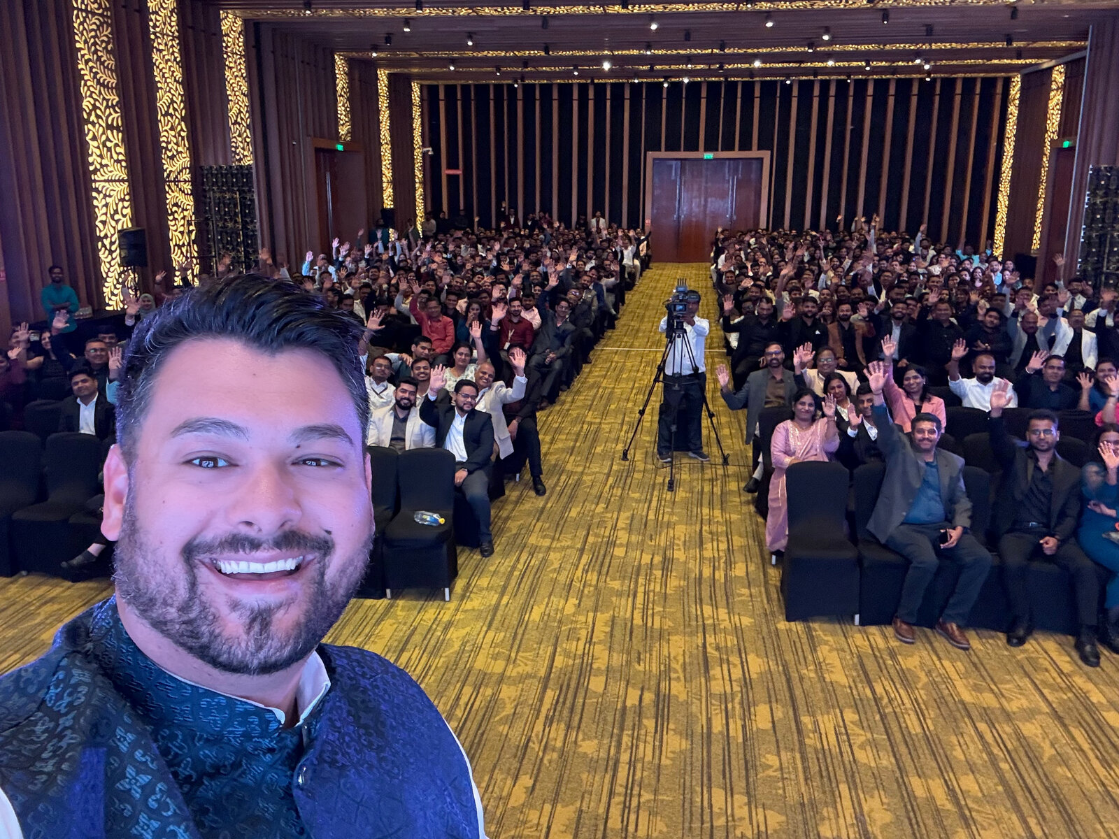 Chris Courneen on stage with a packed audience at a speaking engagement in India